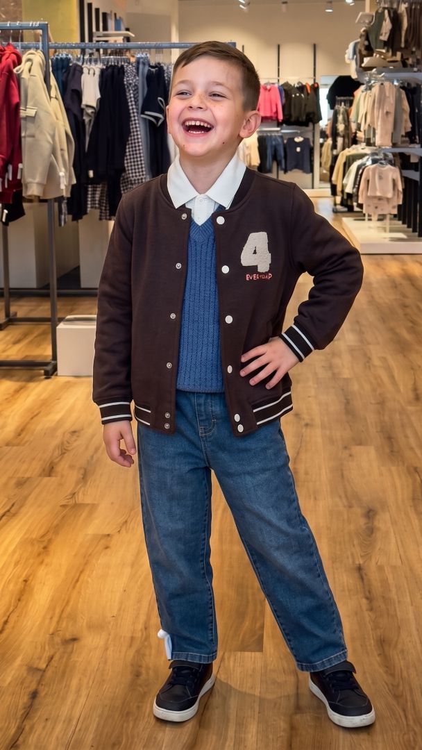 Bub in Collegejacke und Strickpullover