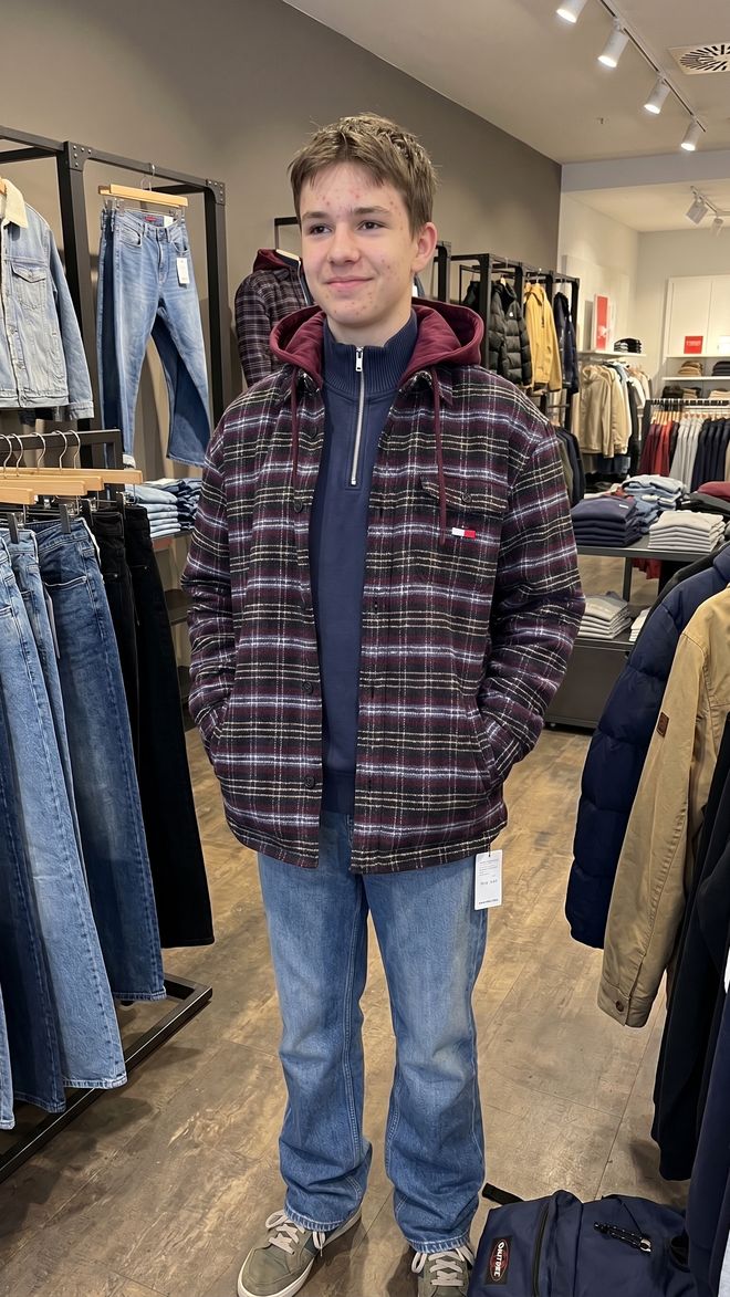 Jugendlicher in karierter Hemdjacke und Jeans